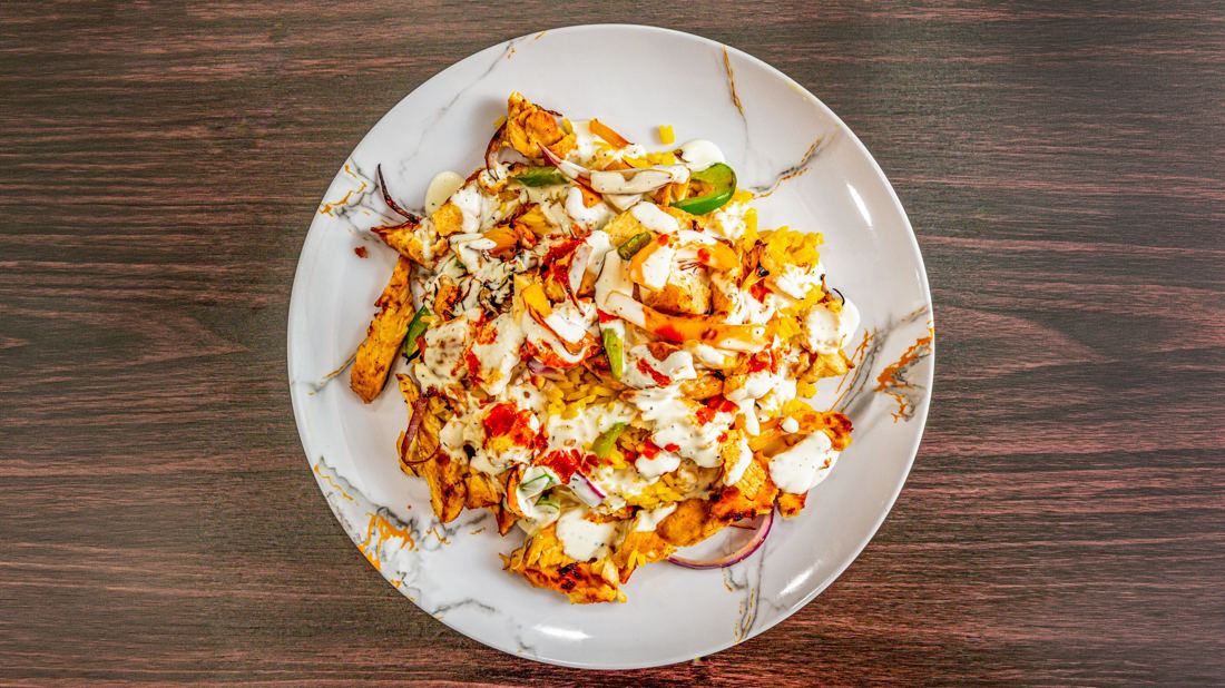 Halal chicken over rice with white and hot sauce