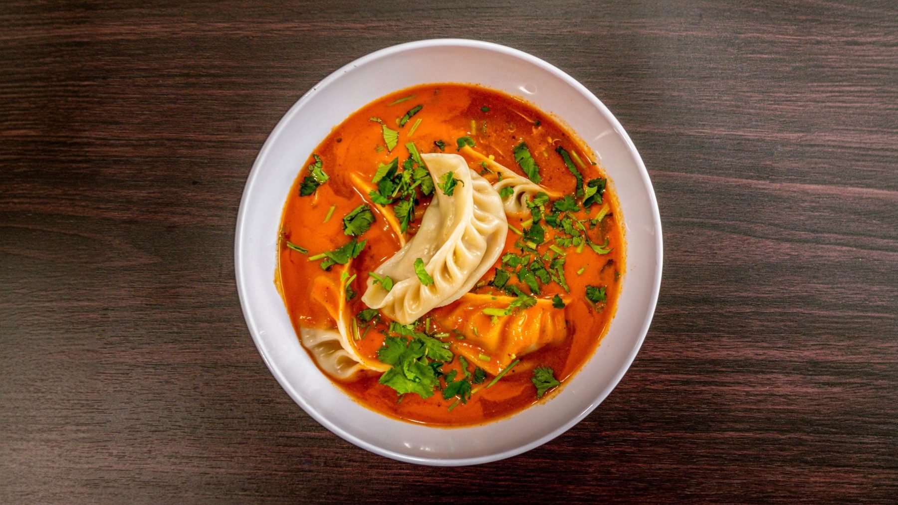 Jhol momo: hand-pleated dumplings in warm tomato-sesame broth