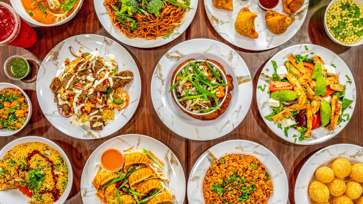 A spread of momos, platters, chowmein, salad and street snacks